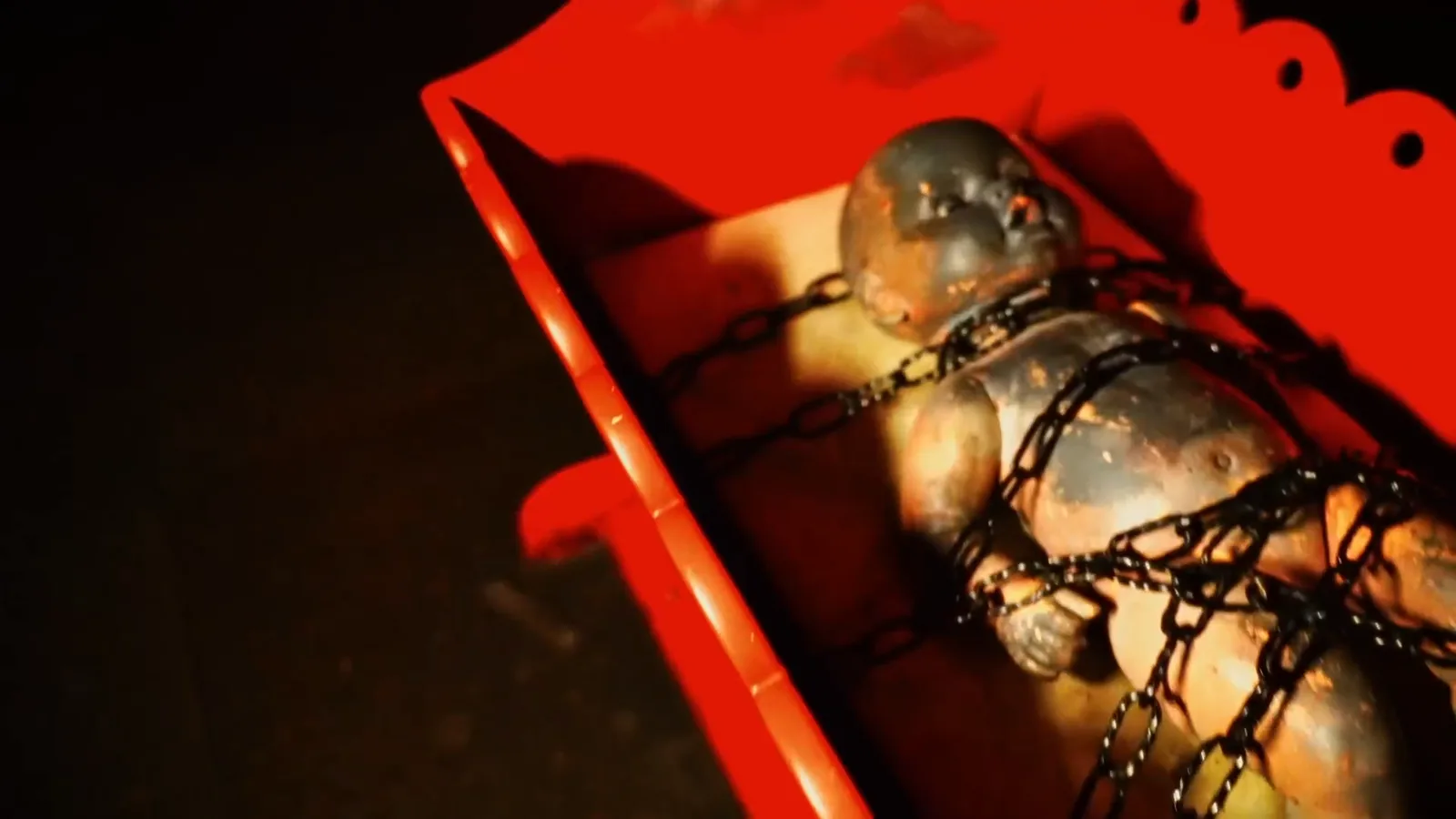 A doll bound in chains inside a red box in The Possession