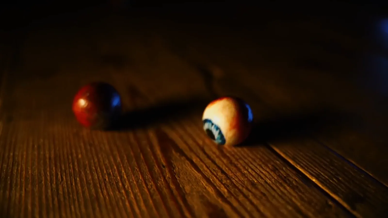 Two loose eyeballs on worn floorboards in The Possession