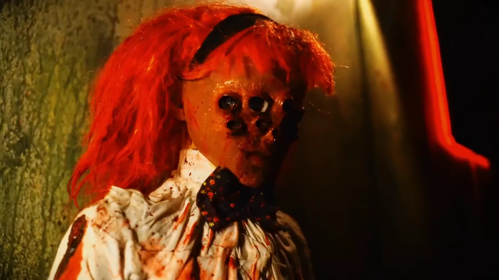 A red-haired doll with clusters of black eyes in The Possession